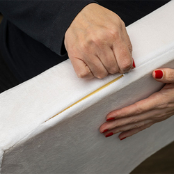 Hände öffnen den Reißverschluss eines Kissenbezugs.